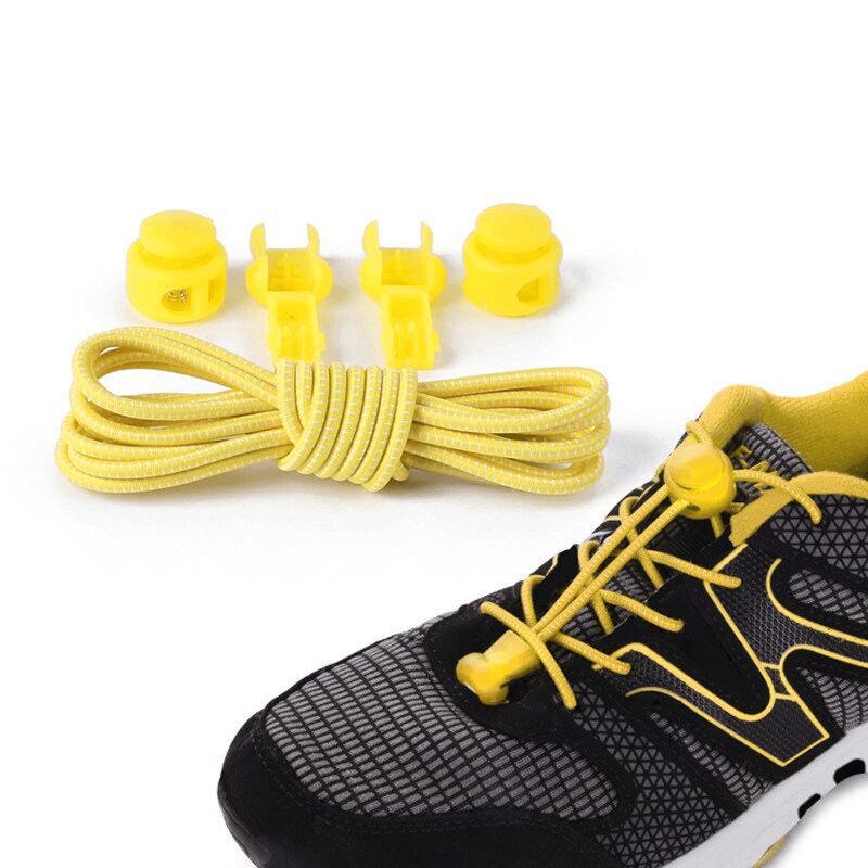 Yellow elastic no-tie shoelaces with spring buckles and clips beside a sports shoe, perfect for easy, stylish footwear solutions.